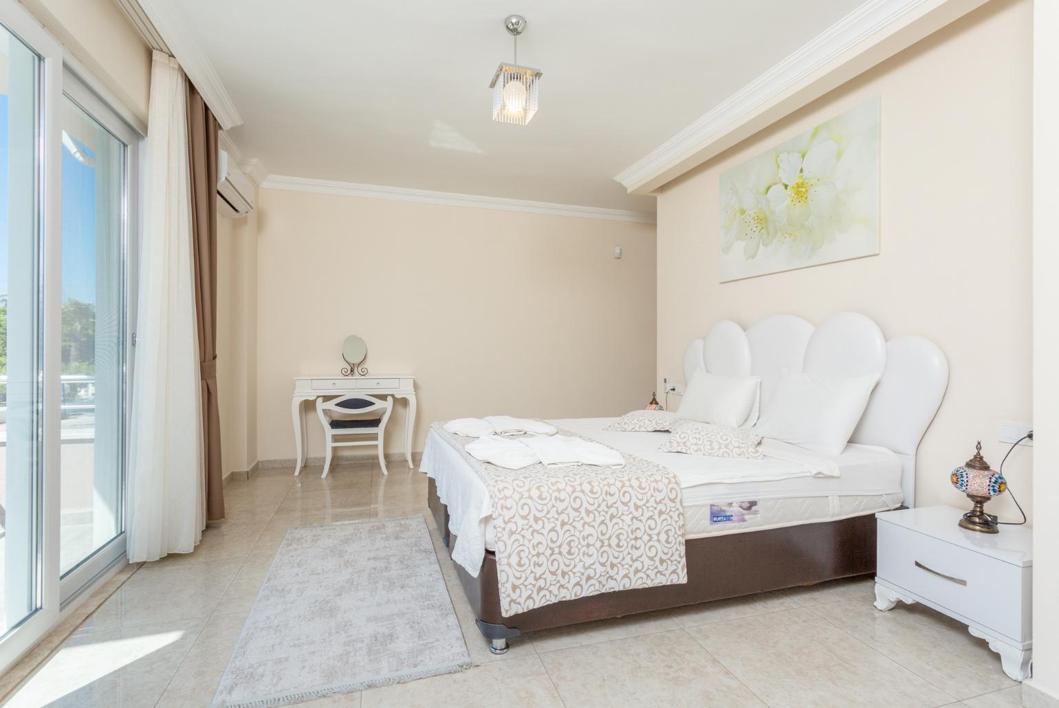 Double bedroom with en suite bathroom, A/C, and balcony access