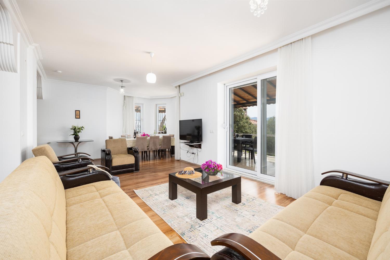 Open-plan living room with sofas, dining area, kitchen, A/C, WiFi internet, satellite TV, and sea views