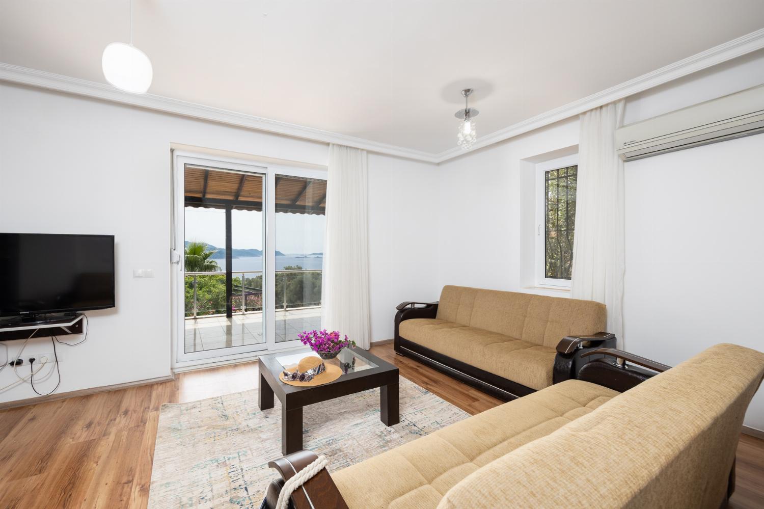 Open-plan living room with sofas, dining area, kitchen, A/C, WiFi internet, satellite TV, and sea views