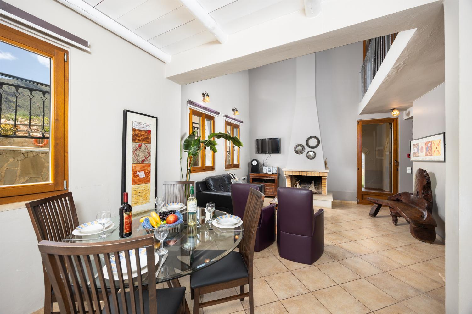 Open-plan living room with sofa, dining area, kitchen, ornamental fireplace, WiFi internet, and satellite TV