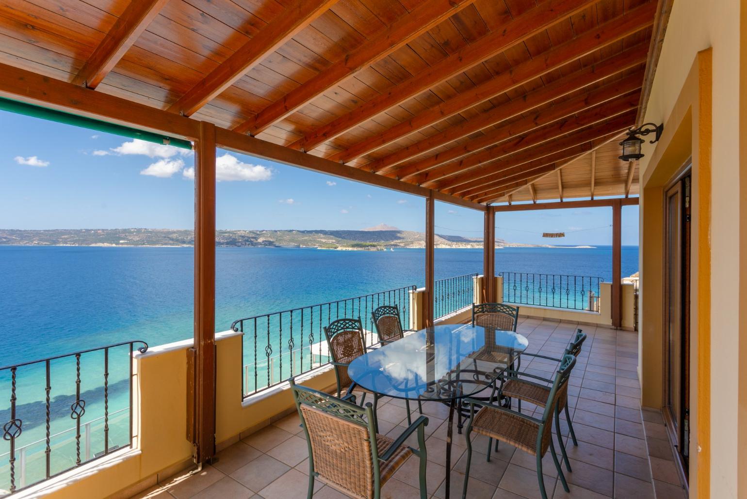 Sheltered balcony with outdoor seating and panoramic sea views