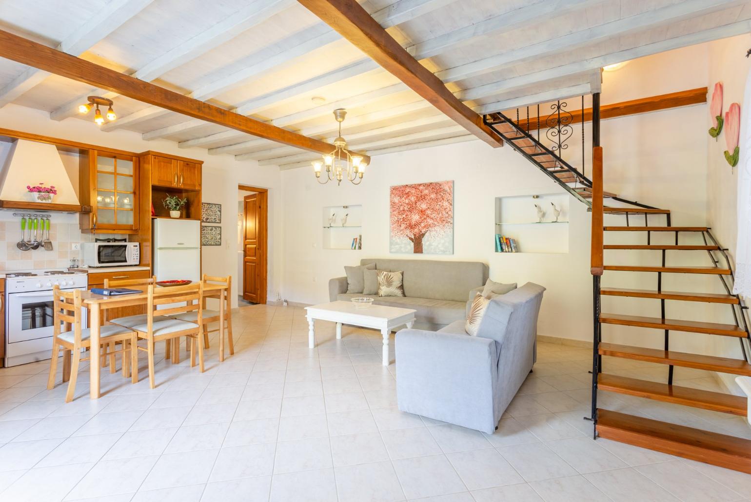 Open-plan living room with sofas, DVD player and dining area.