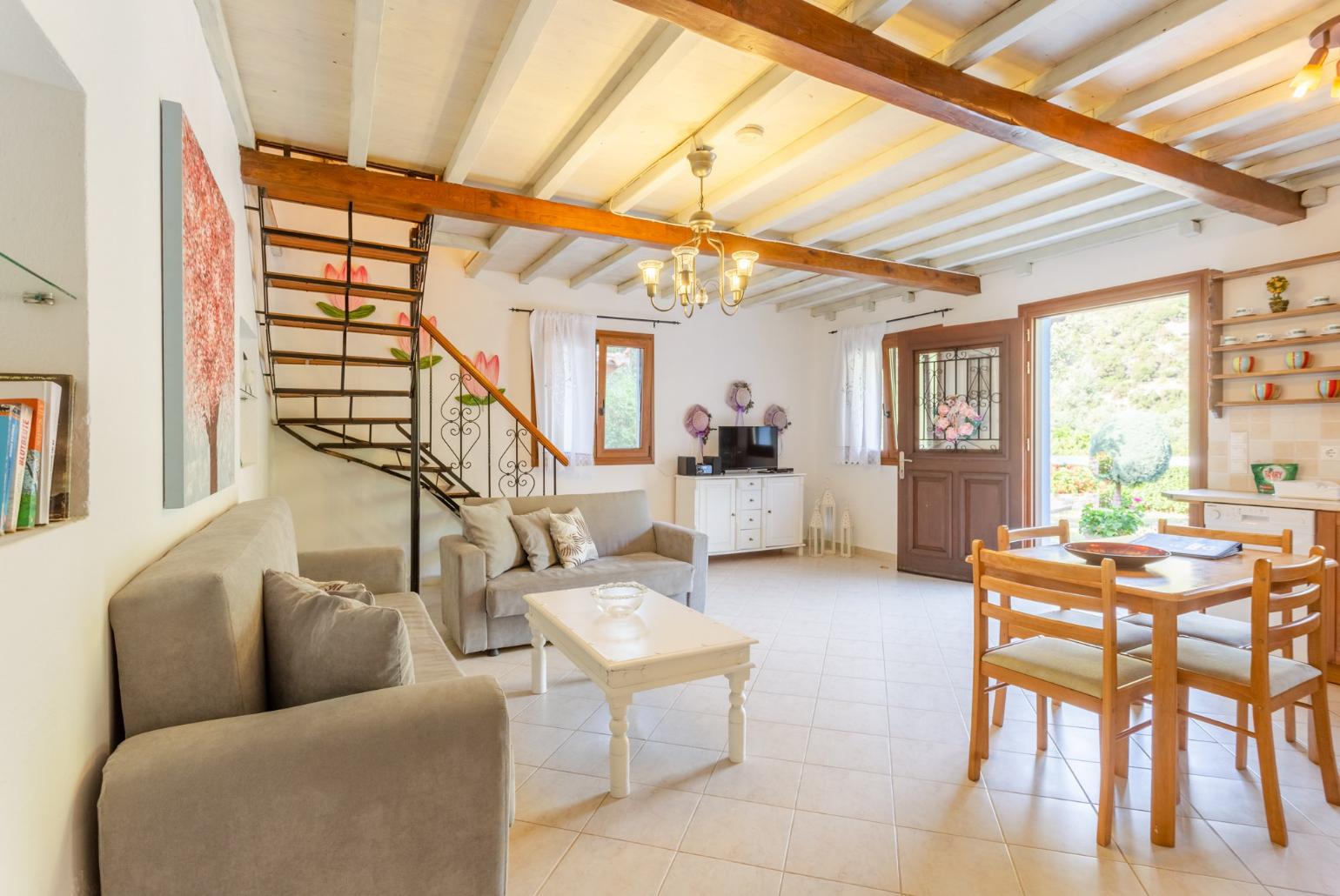 Open-plan living room with sofas, DVD player and dining area.