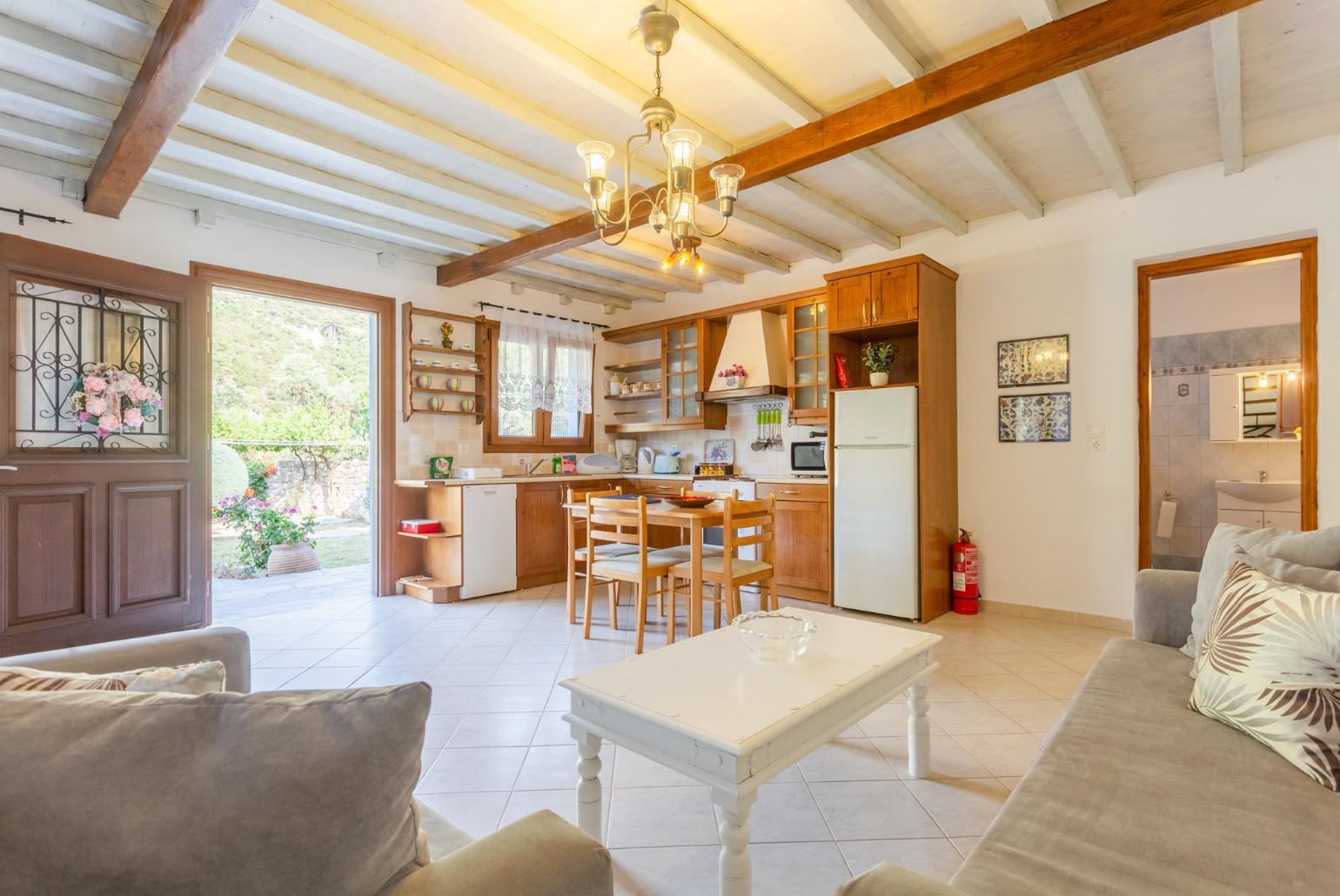 Open-plan living room with sofas, DVD player and dining area.