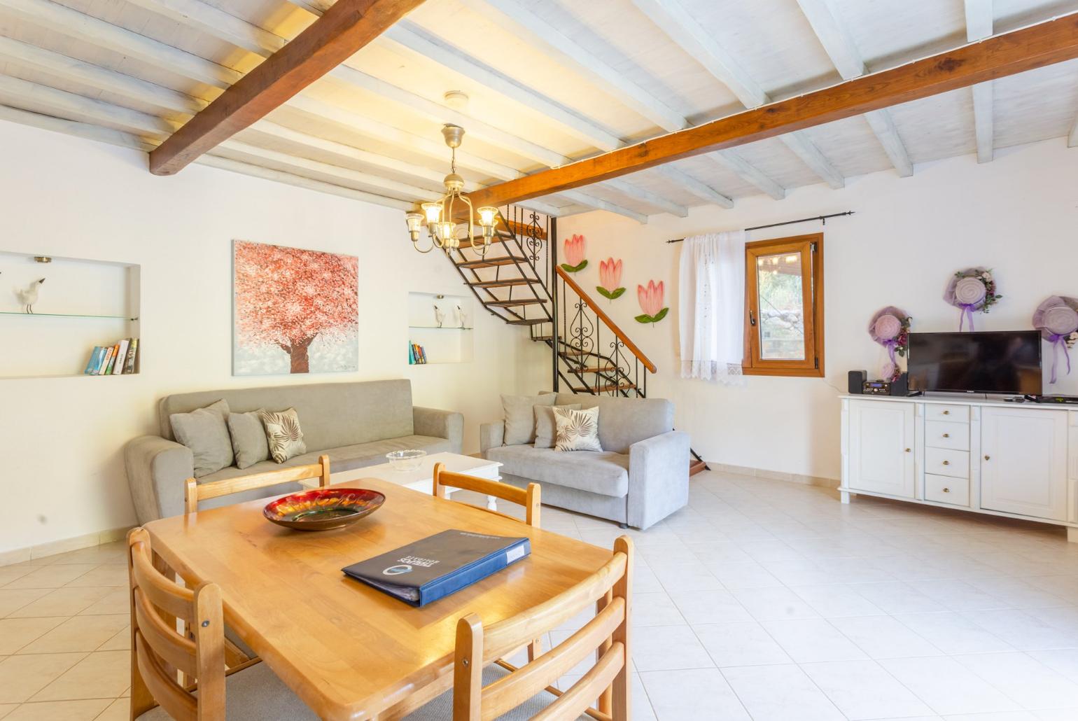 Open-plan living room with sofas, DVD player and dining area.