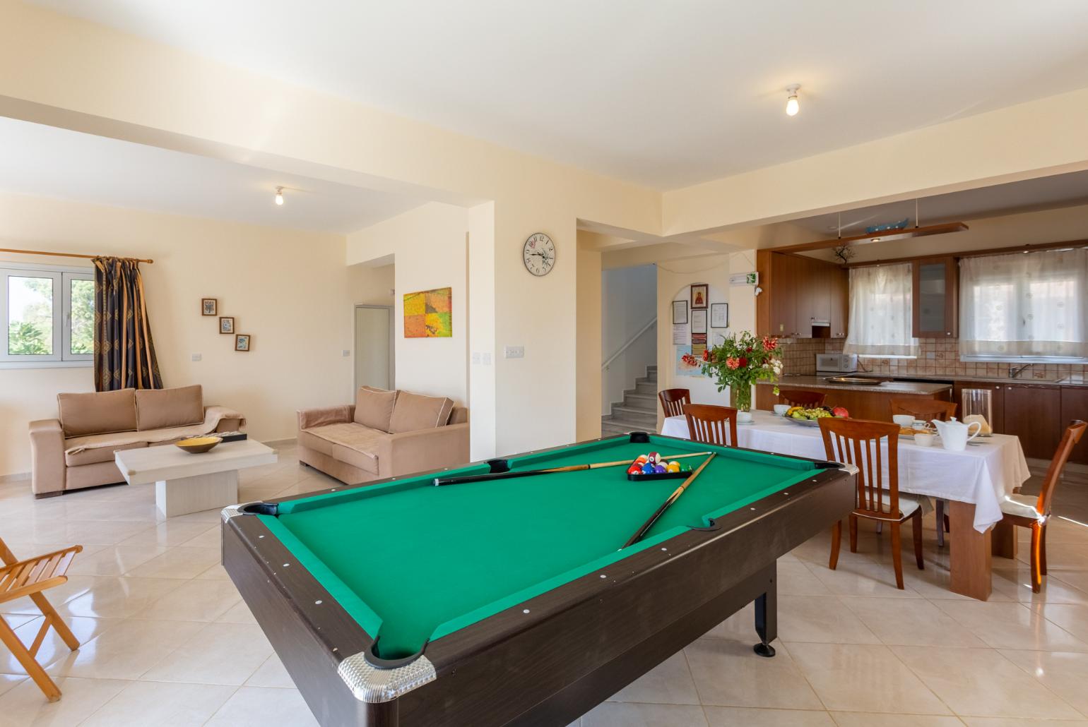 Open-plan living room with sofas, dining area, kitchen, ornamental fireplace, A/C, WiFi internet, satellite TV, pool table, foosball table, and terrace access with sea views