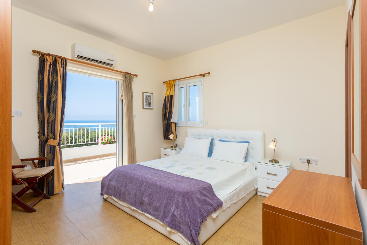 Double bedroom with en suite bathroom, A/C, and upper terrace access with panoramic sea views