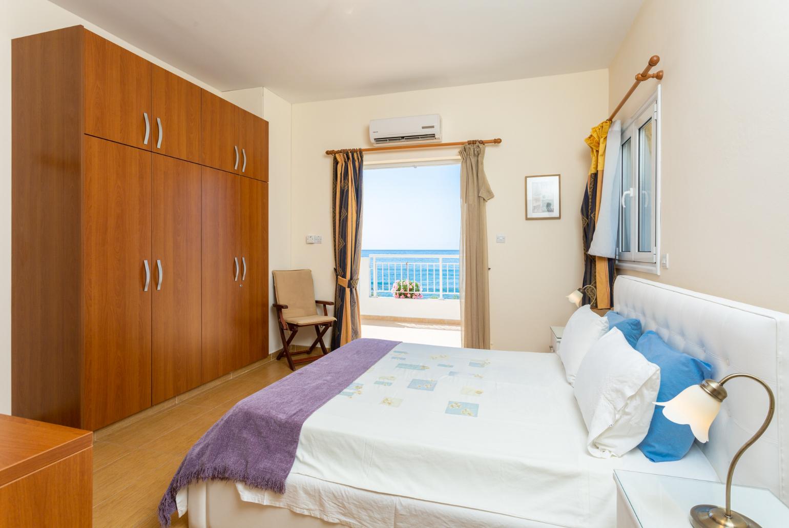 Double bedroom with en suite bathroom, A/C, and upper terrace access with panoramic sea views