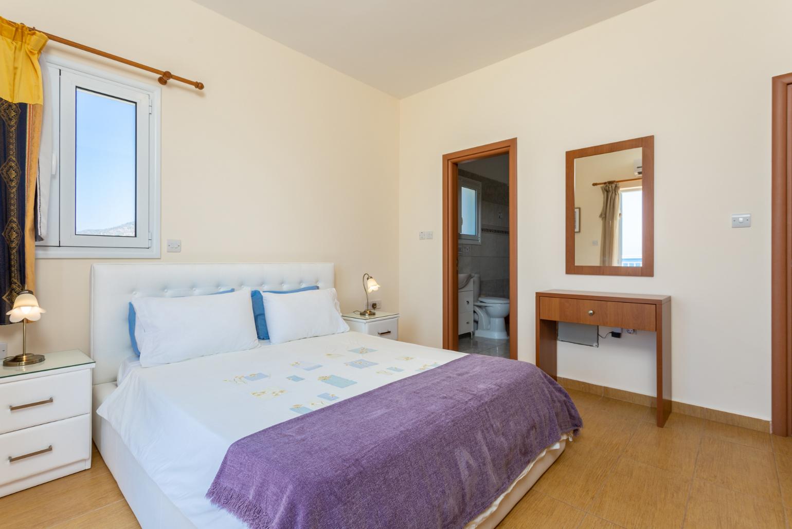 Double bedroom with en suite bathroom, A/C, and upper terrace access with panoramic sea views