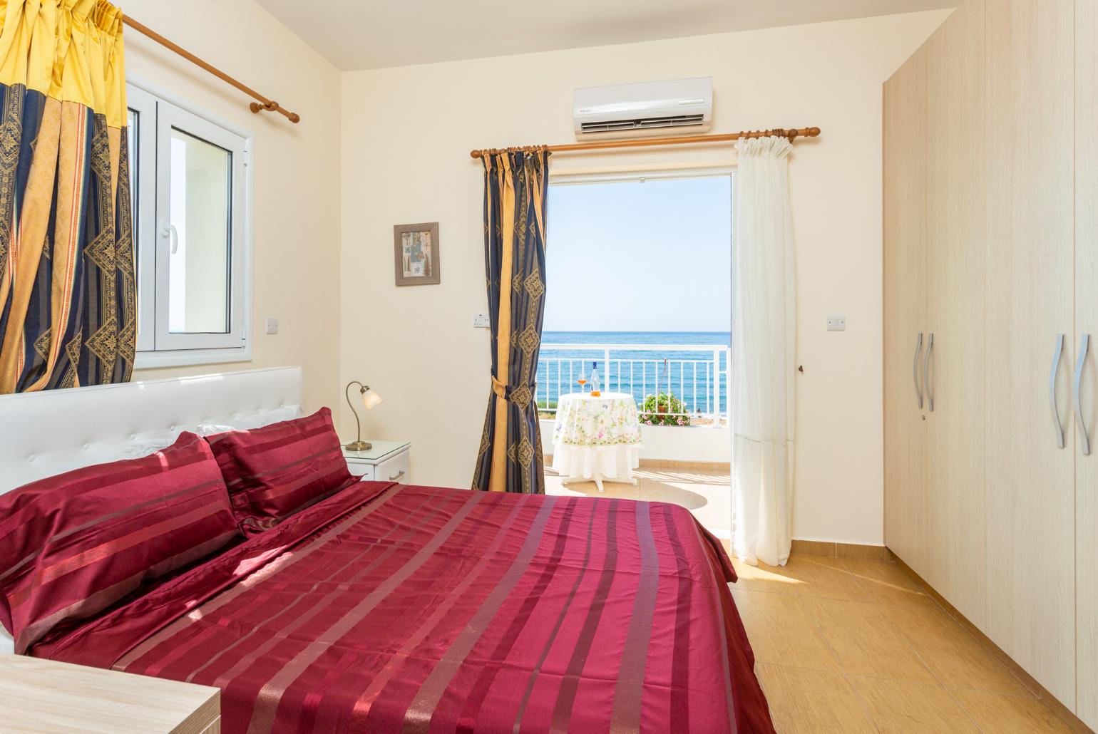 Double bedroom with en suite bathroom, A/C, and upper terrace access with panoramic sea views