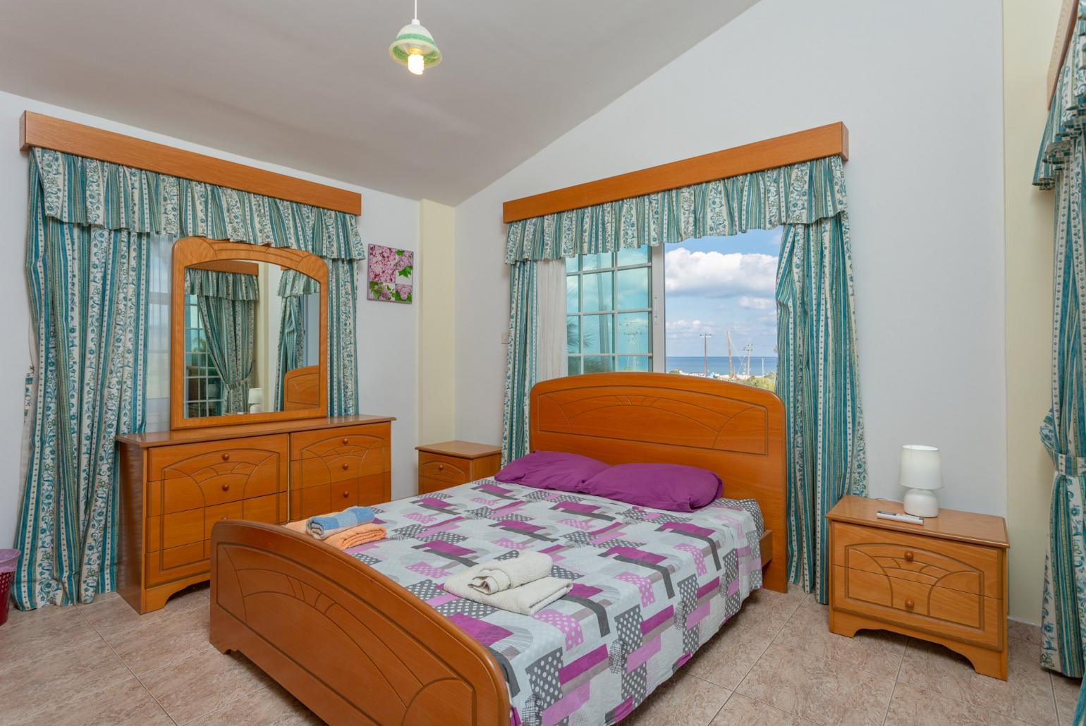 Double bedroom with en suite bathroom, A/C, and balcony access with sea views