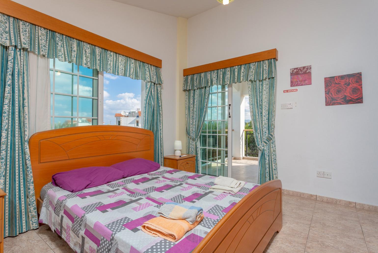 Double bedroom with en suite bathroom, A/C, and balcony access with sea views