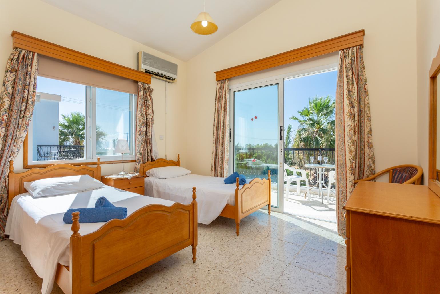 Twin bedroom with en suite bathroom, A/C, and balcony access with sea views