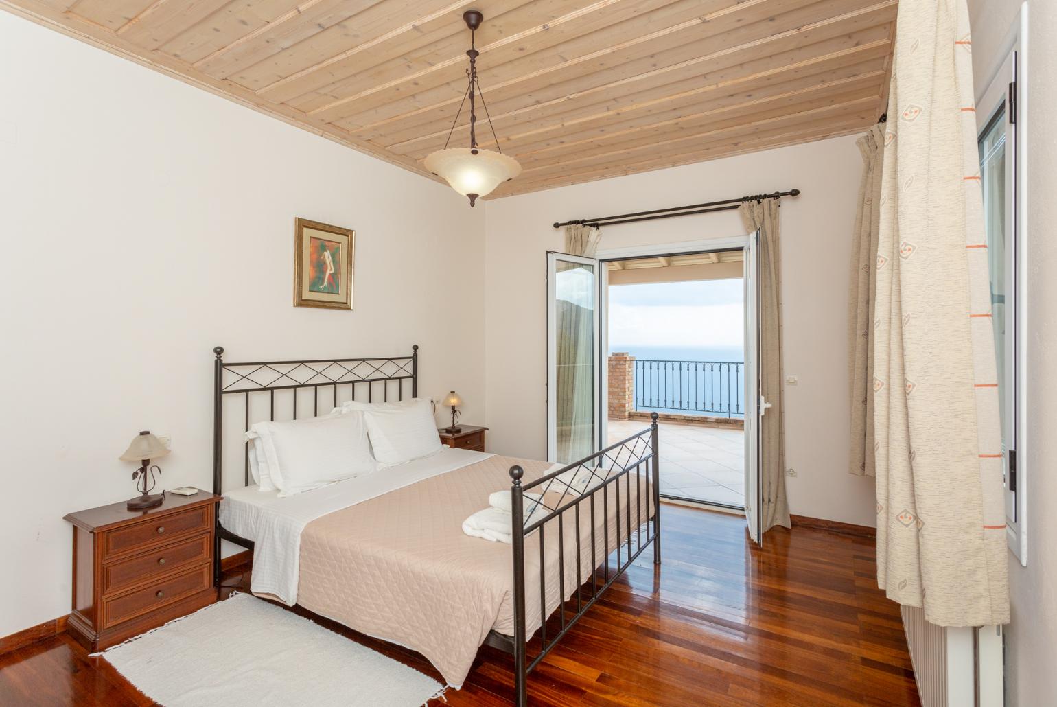 Double bedroom with en suite bathroom, A/C, and upper terrace access with panoramic sea views