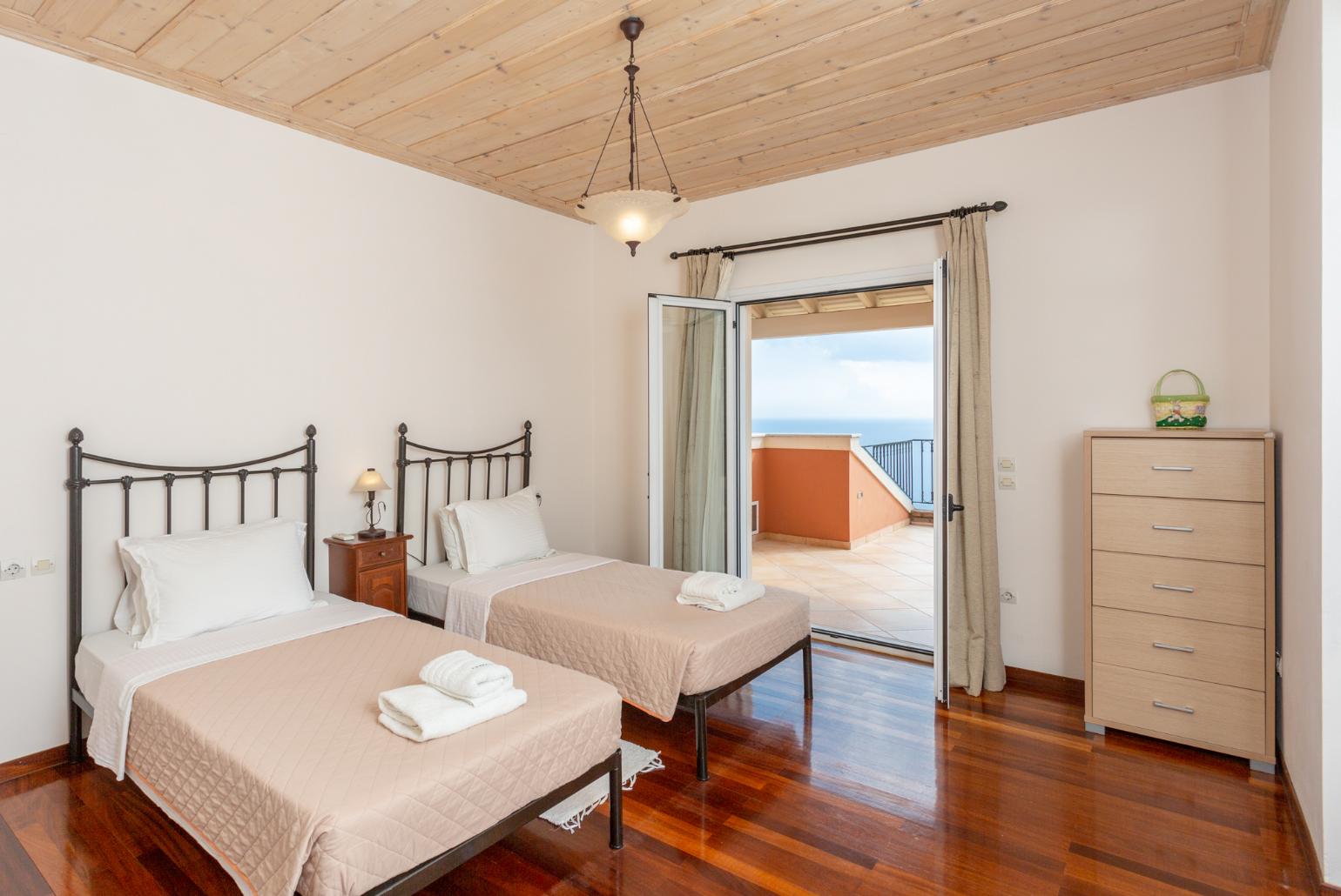 Twin bedroom with en suite bathroom, A/C, and upper terrace access with panoramic sea views