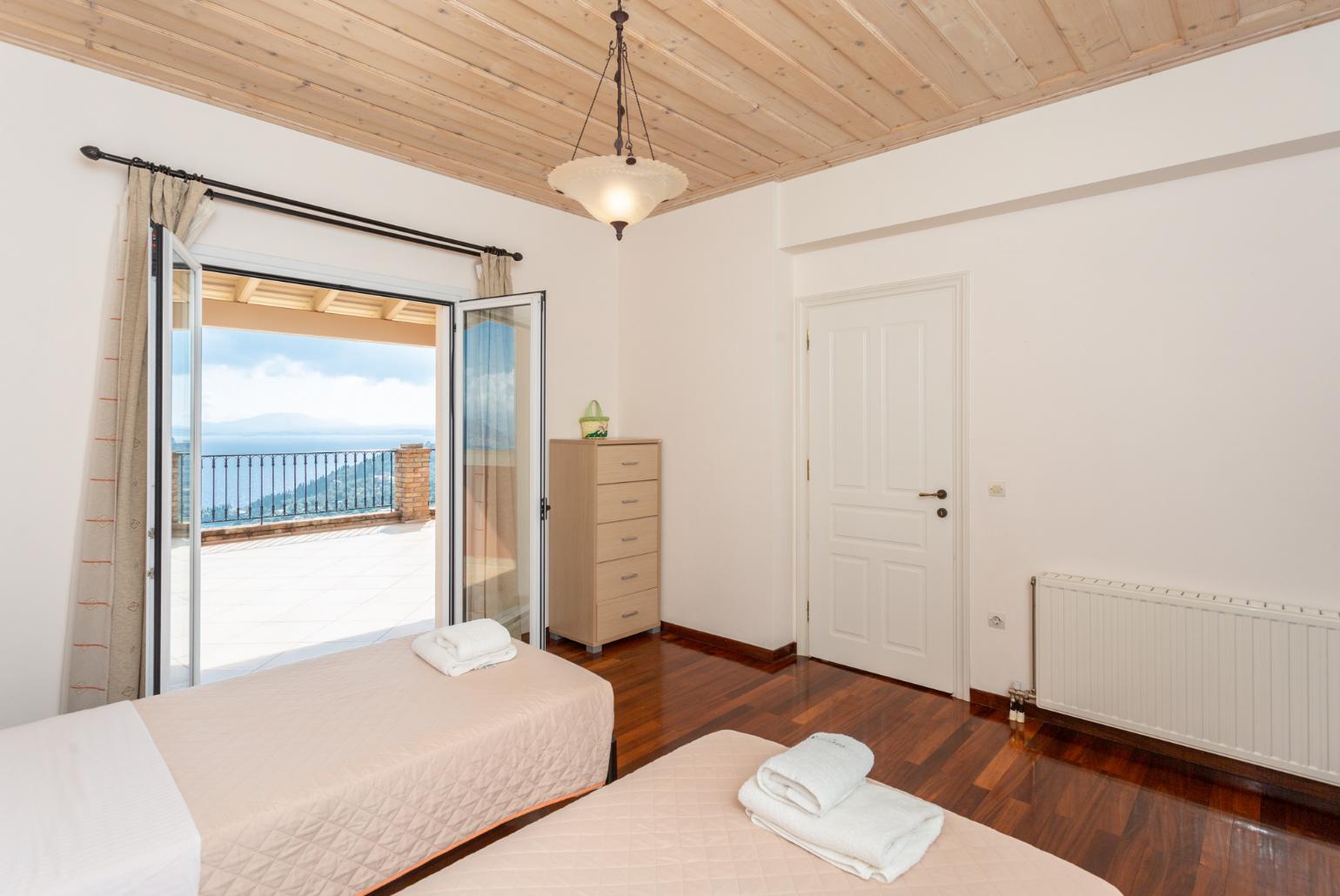 Twin bedroom with en suite bathroom, A/C, and upper terrace access with panoramic sea views