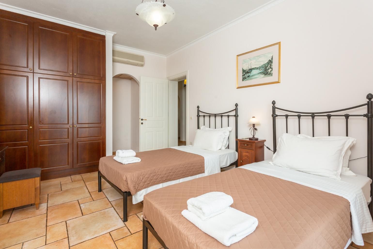 Twin bedroom with en suite bathroom, A/C, and pool terrace access with panoramic sea views
