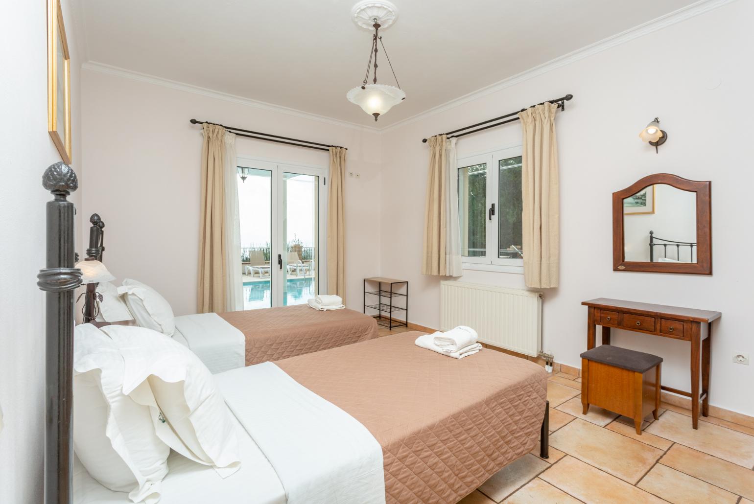 Twin bedroom with en suite bathroom, A/C, and pool terrace access with panoramic sea views