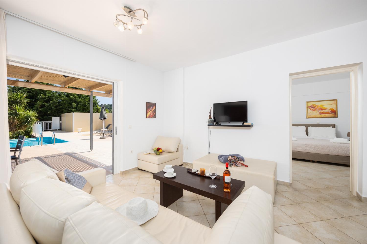 Open-plan living room with sofa, dining area, kitchen, A/C, WiFi internet, and satellite TV