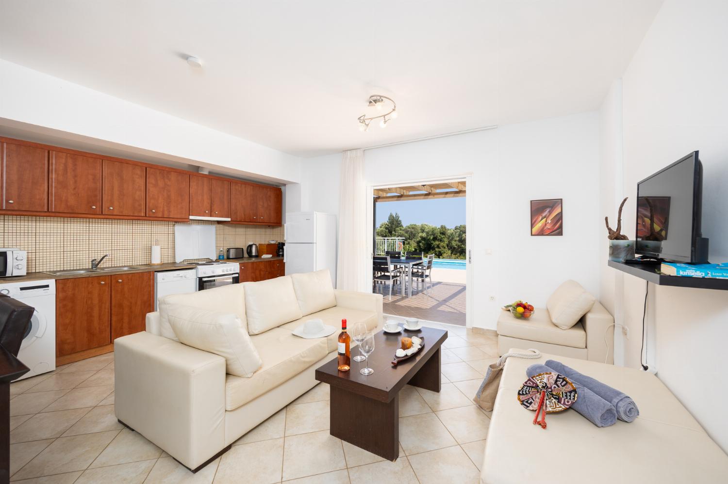 Open-plan living room with sofa, dining area, kitchen, A/C, WiFi internet, and satellite TV