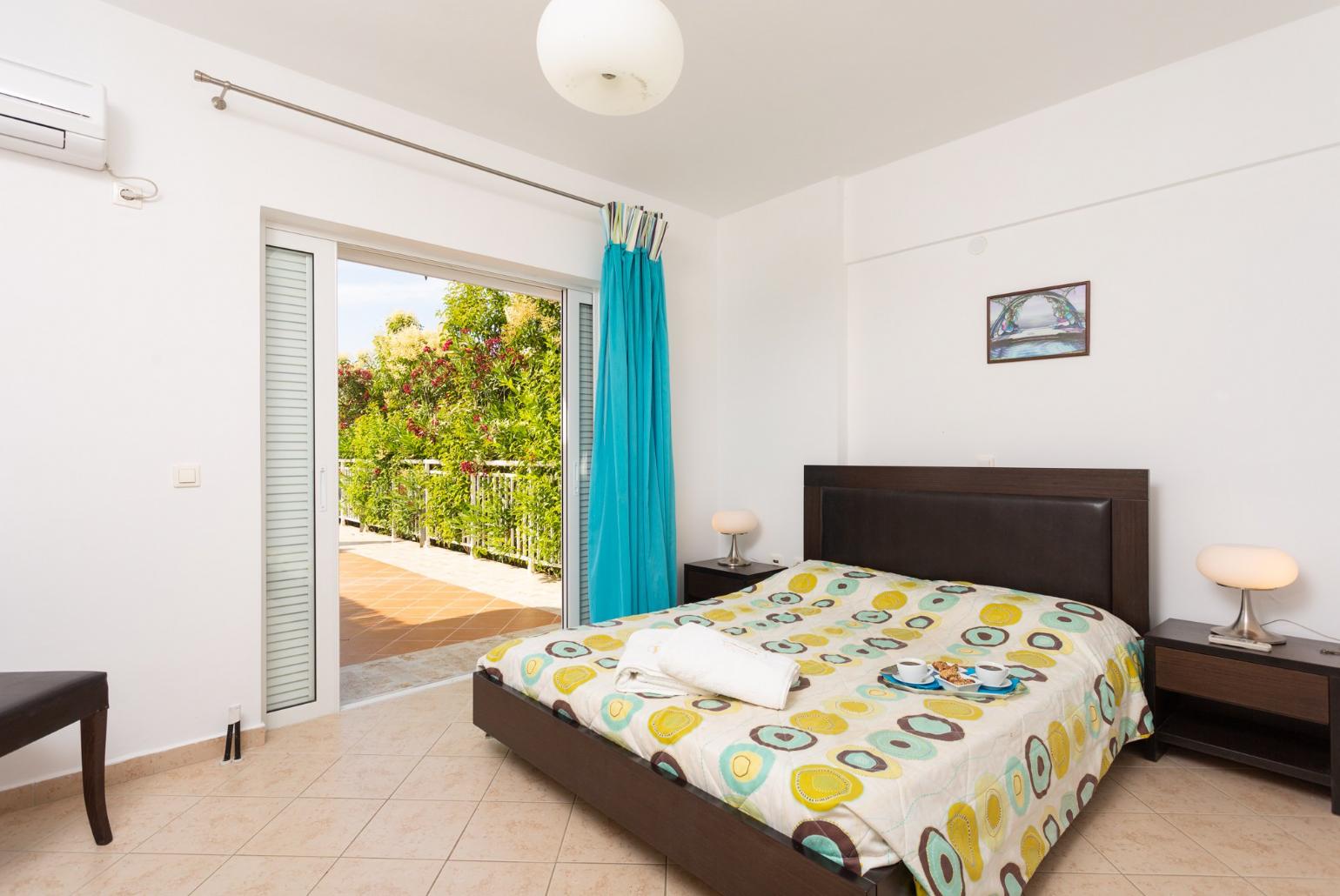 Double bedroom with A/C, en suite bathroom, and terrace access
