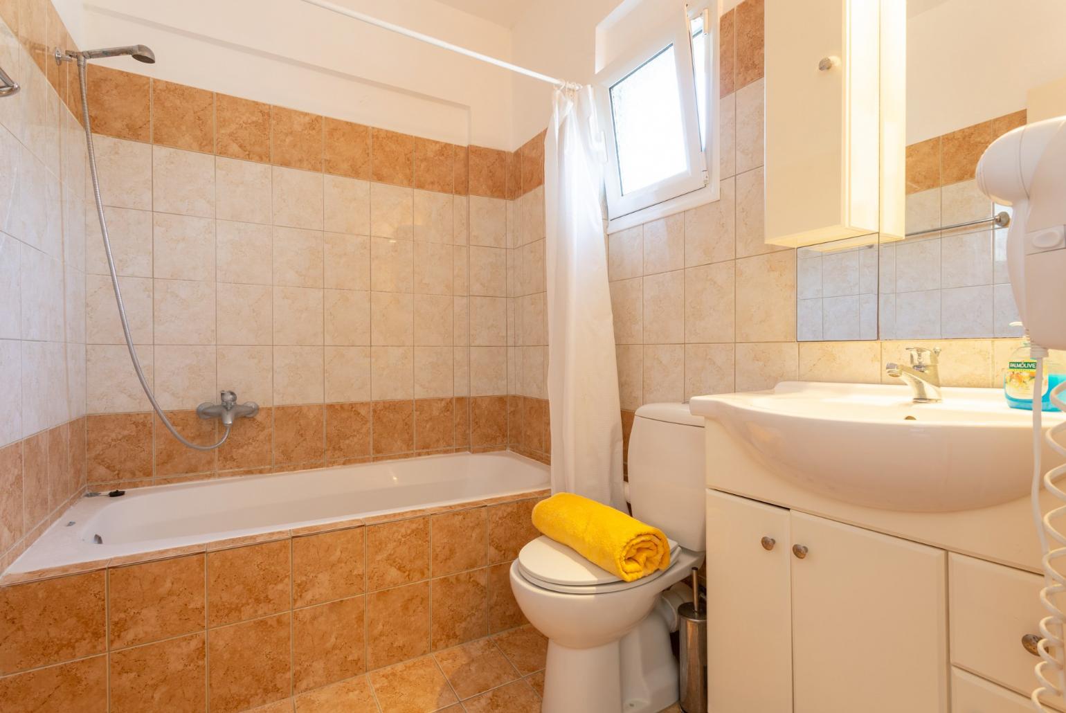 En suite bathroom with bath and overhead shower