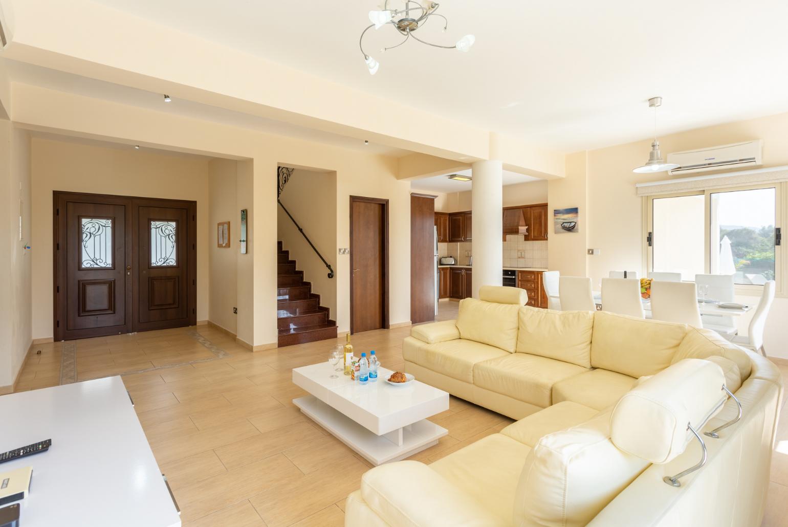 Open-plan living room with sofas, dining area, kitchen, ornamental fireplace, A/C, WiFi internet, and satellite TV