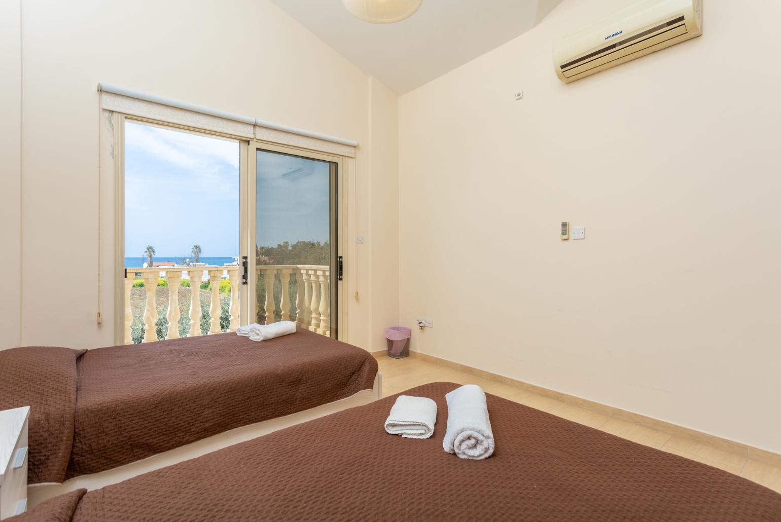 Twin bedroom with A/C, sea views, and balcony access