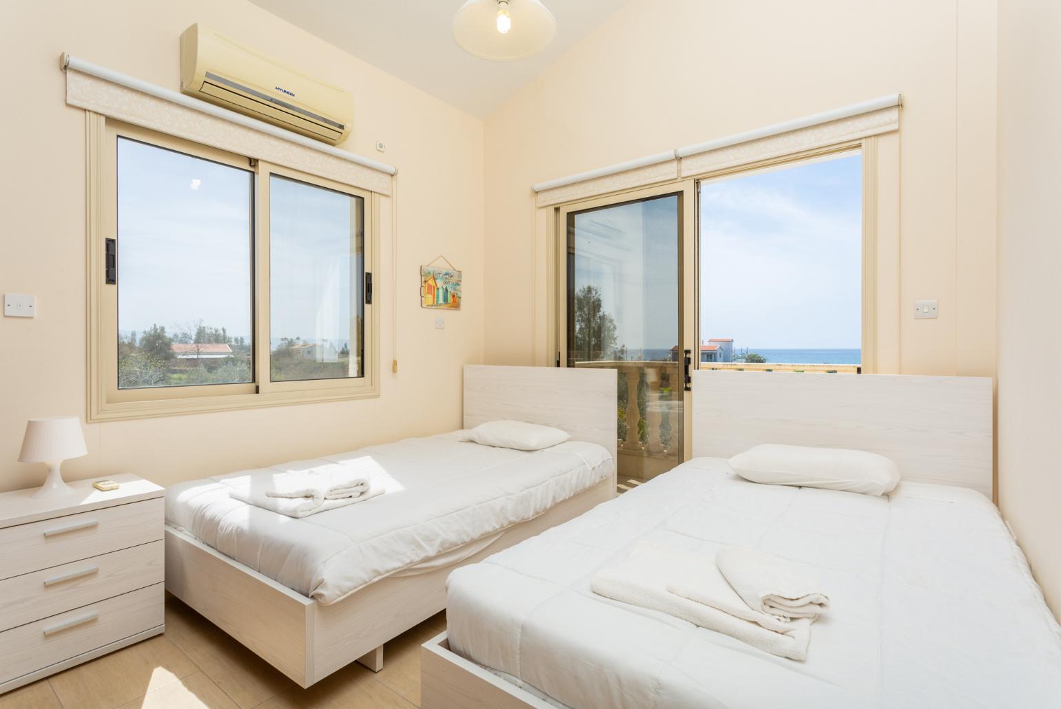 Twin bedroom with A/C, sea views, and balcony access