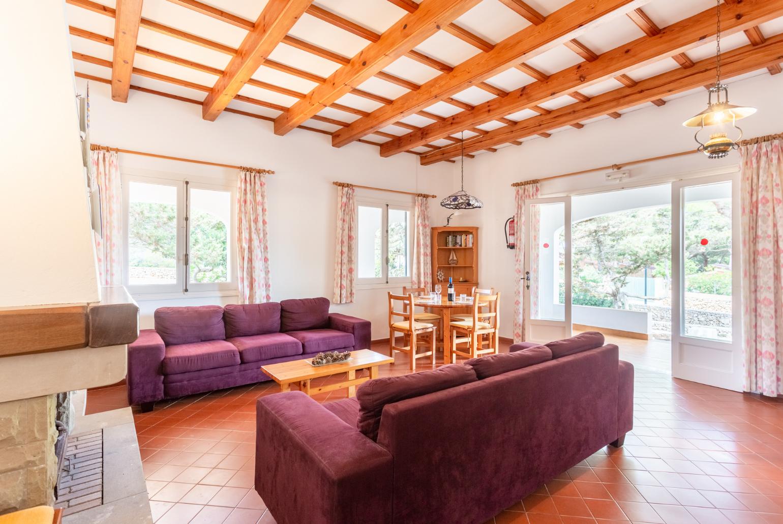 Living room with sofas, dining area, ornamental fireplace, WiFi internet, TV, and terrace access