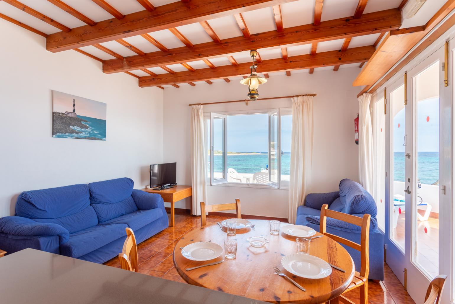 Open-plan living room with sofas, dining area, kitchen, WiFi internet, TV, and sea views