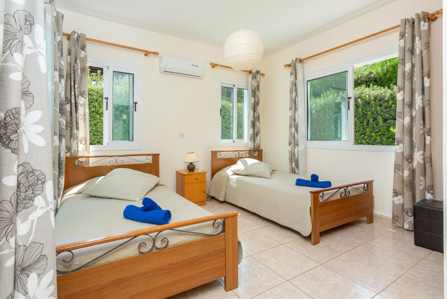 Twin bedroom with en suite bathroom, A/C, and terrace access