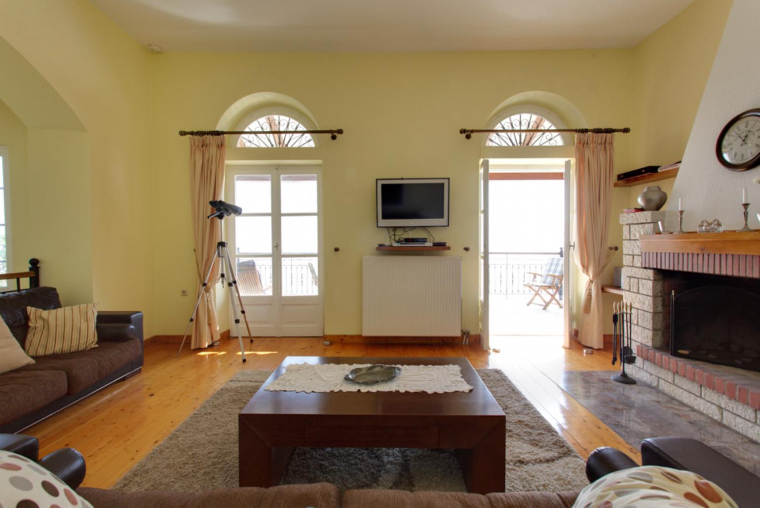 Living area with WiFi, ornamental fireplace, TV, DVD player and terrace access 