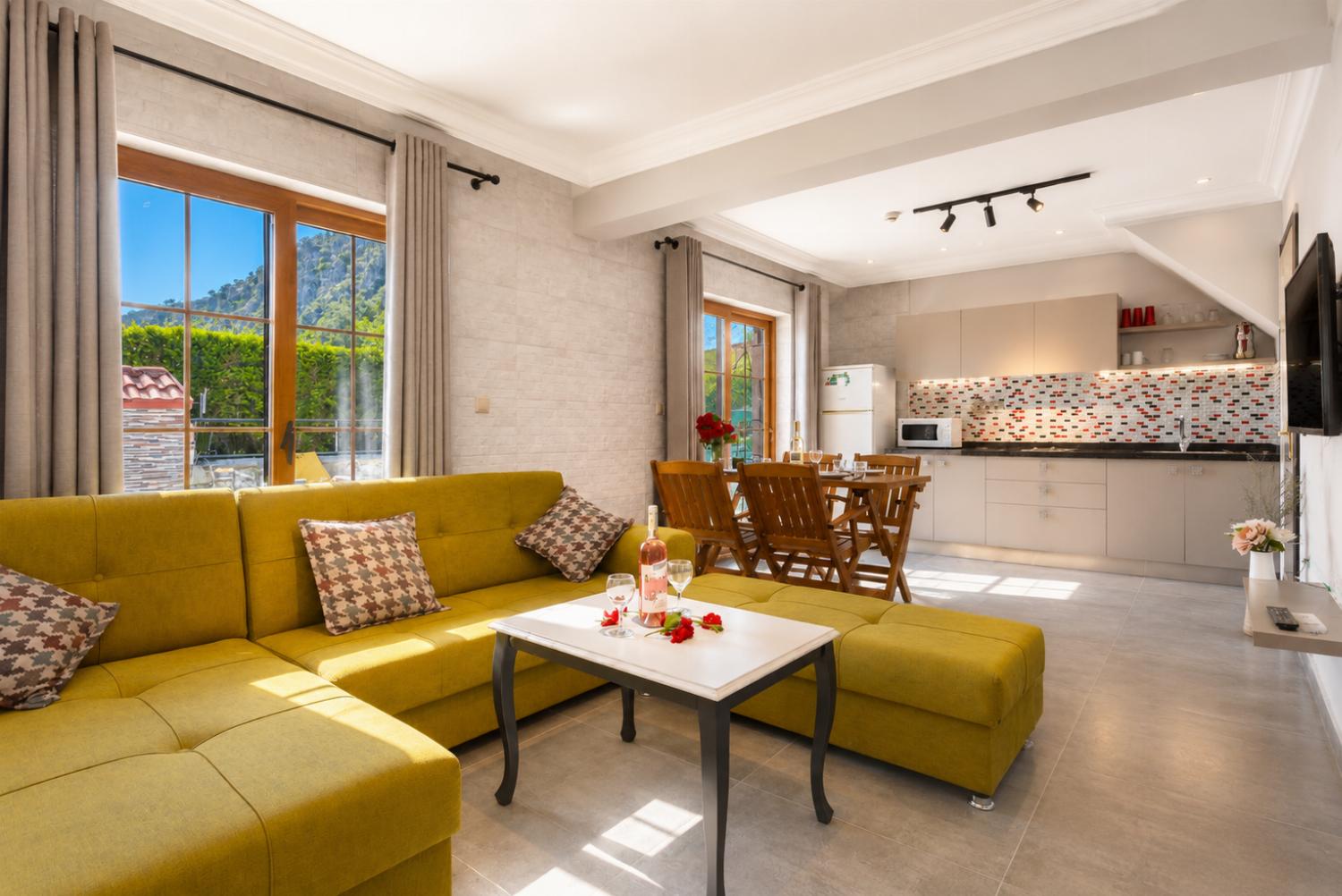 Open-plan living room with sofa, dining area, kitchen, A/C, WiFi internet, satellite TV, and terrace access