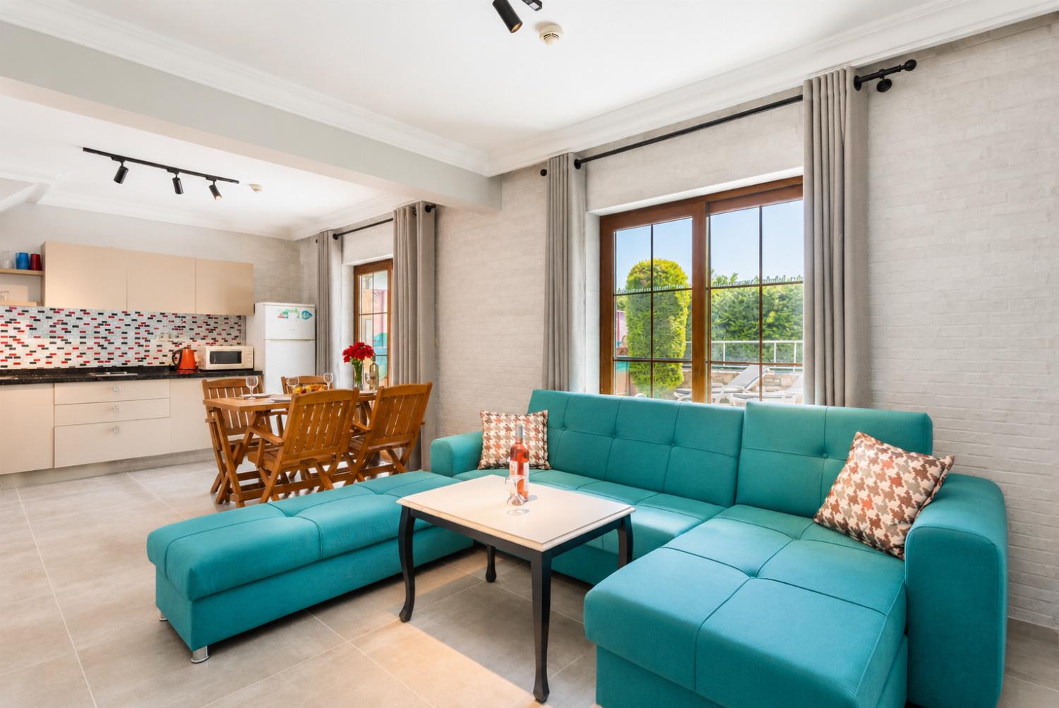 Open-plan living room with sofas, dining area, kitchen, A/C, WiFi internet, satellite TV, and terrace access