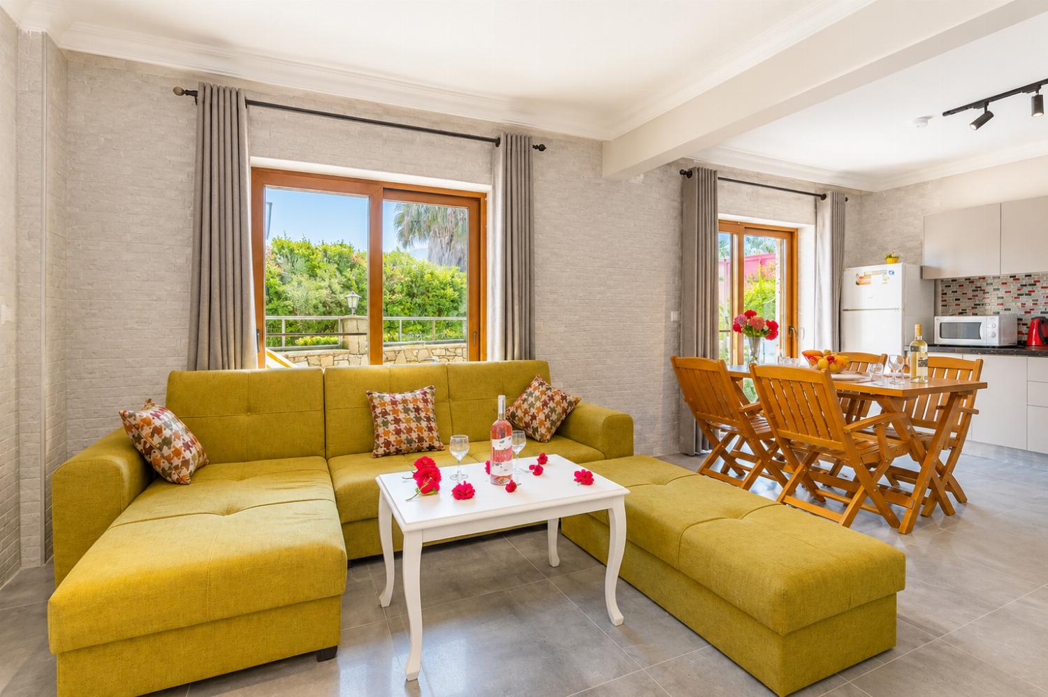 Open-plan living room with sofa, dining area, kitchen, A/C, WiFi internet, satellite TV, and terrace access