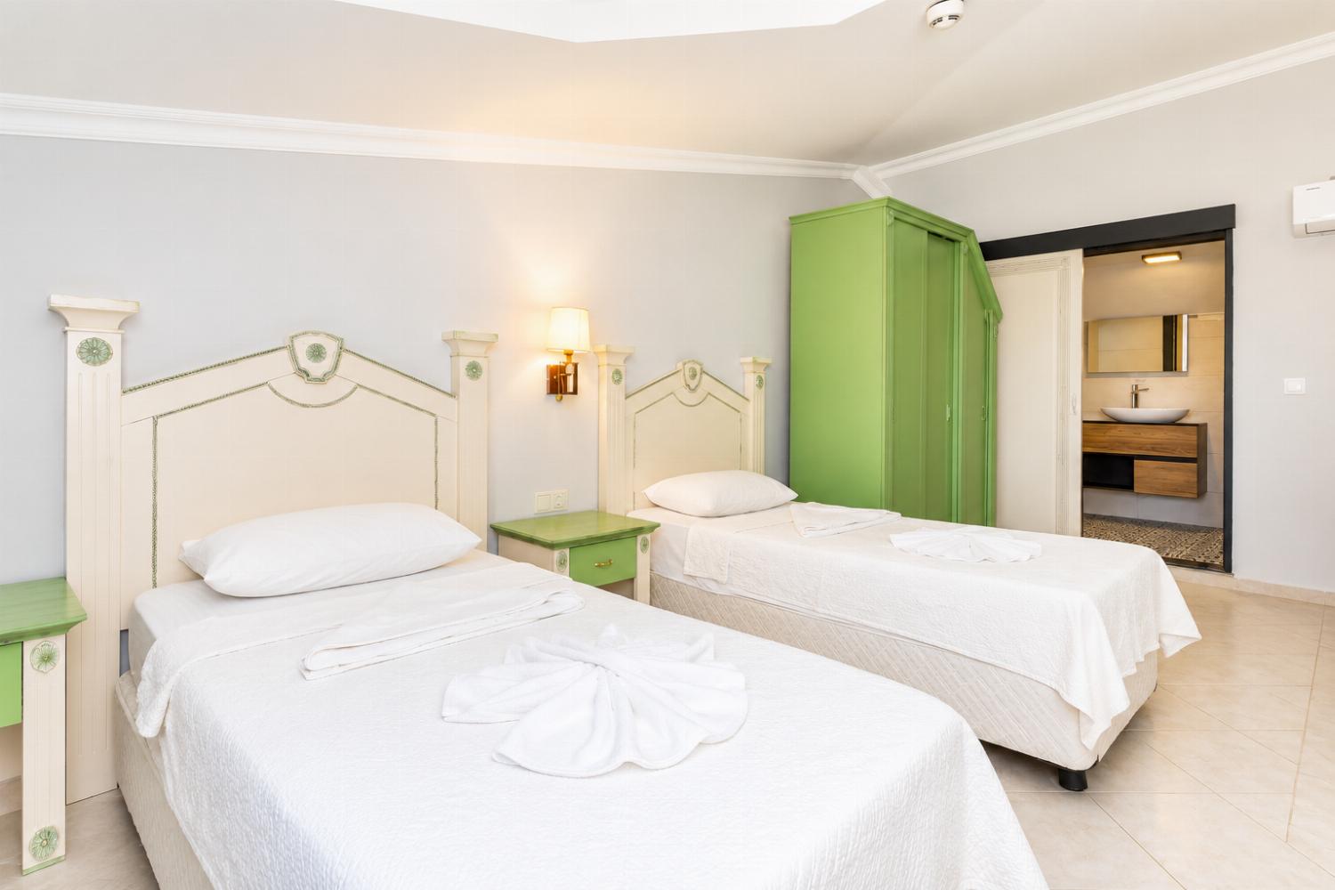 Twin bedroom with en suite bathroom and shower