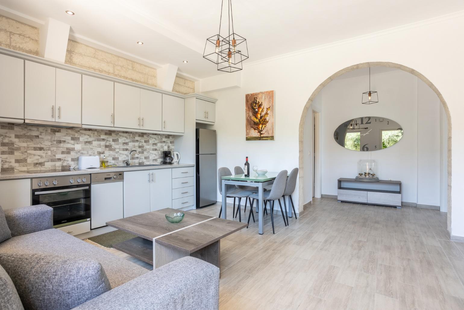 Open-plan living room with sofa, dining area, kitchen, WiFi internet, and terrace access