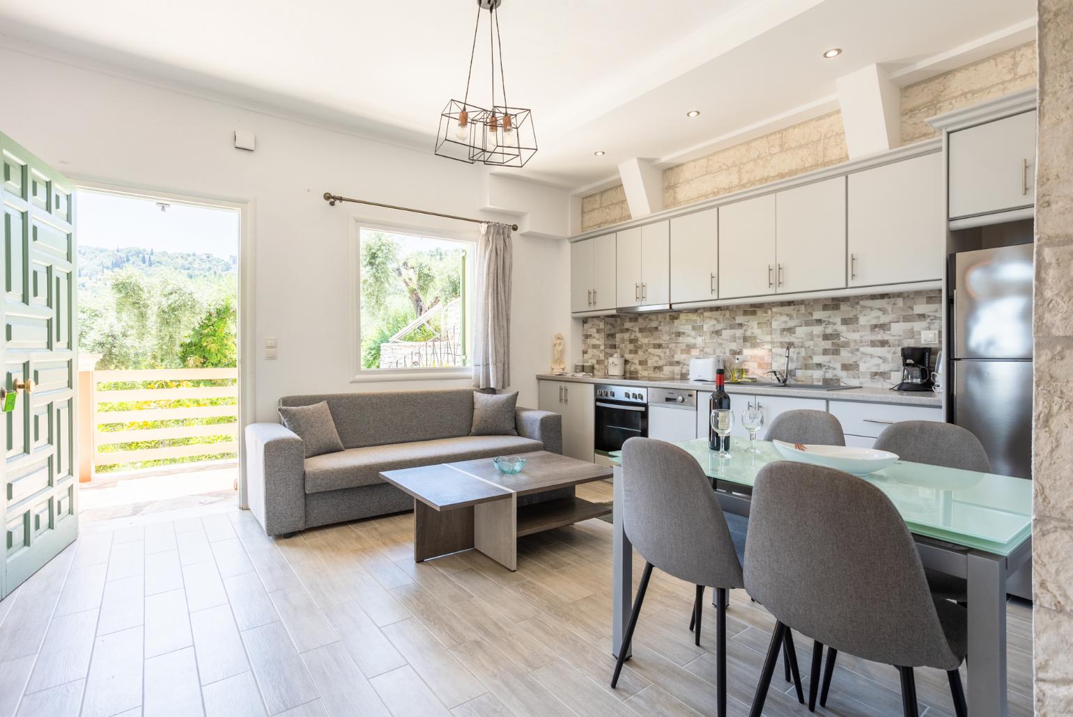 Open-plan living room with sofa, dining area, kitchen, WiFi internet, and terrace access