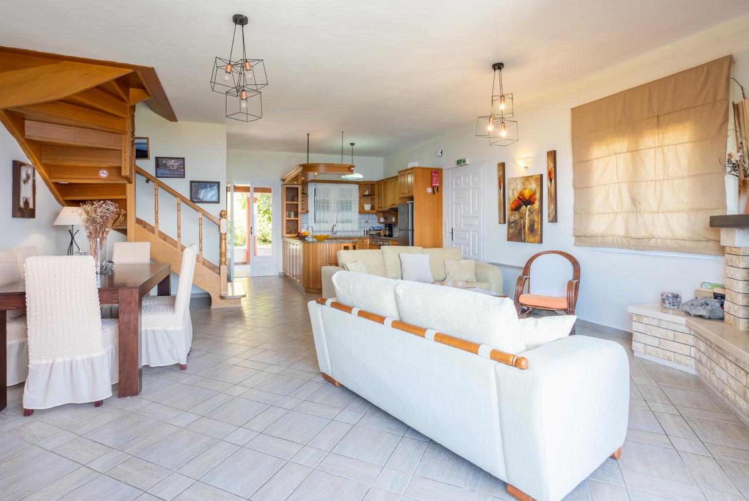 Open-plan living room with sofas, dining area, kitchen, ornamental fireplace, WiFi internet, satellite TV, and balcony access with panoramic sea views