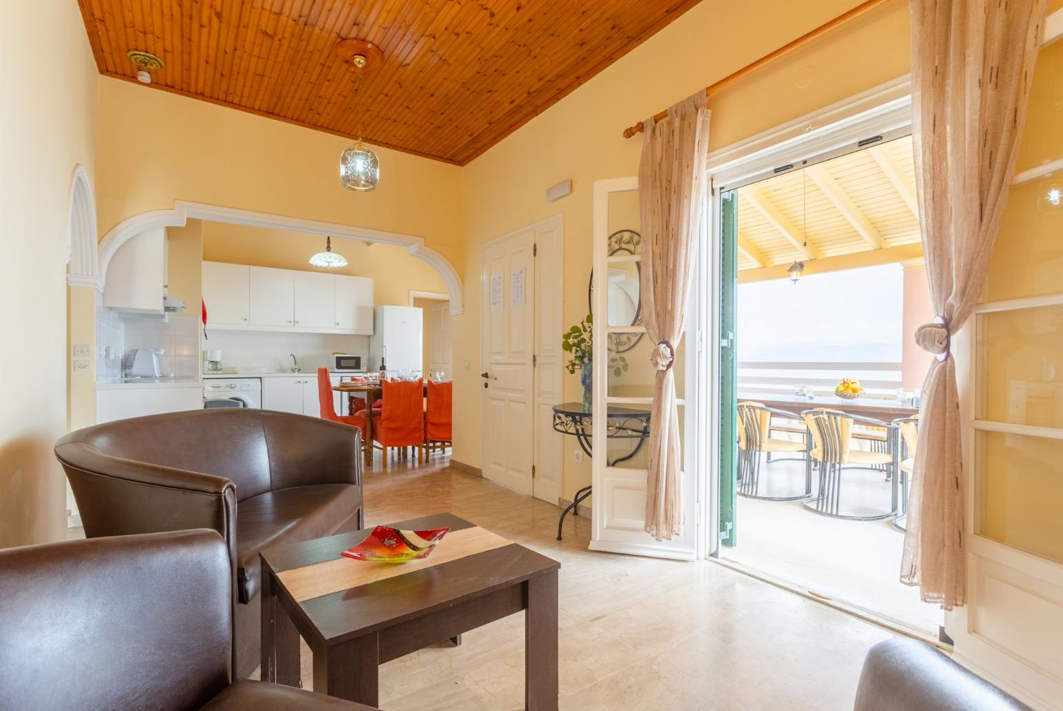 Open-plan living room with sofas, dining area, kitchen, WiFi internet, satellite TV, DVD player, and balcony access with sea views