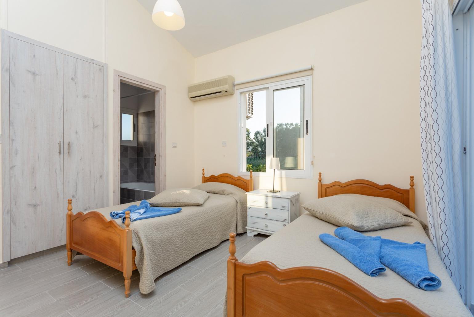 Twin bedroom with en suite bathroom, A/C, and balcony with sea views