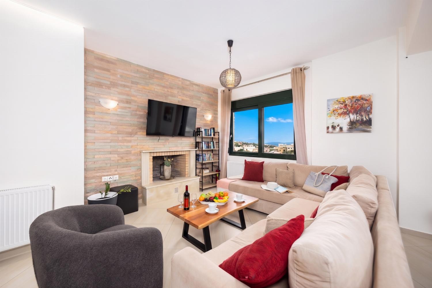 Open-plan living room with sofa, dining area, kitchen, ornamental fireplace, WiFi internet, and satellite TV
