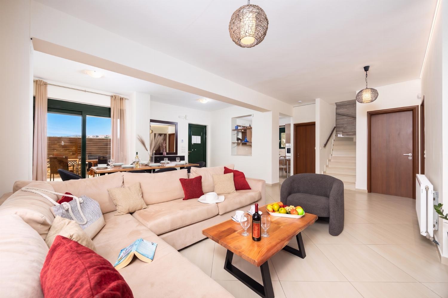 Open-plan living room with sofa, dining area, kitchen, ornamental fireplace, WiFi internet, and satellite TV