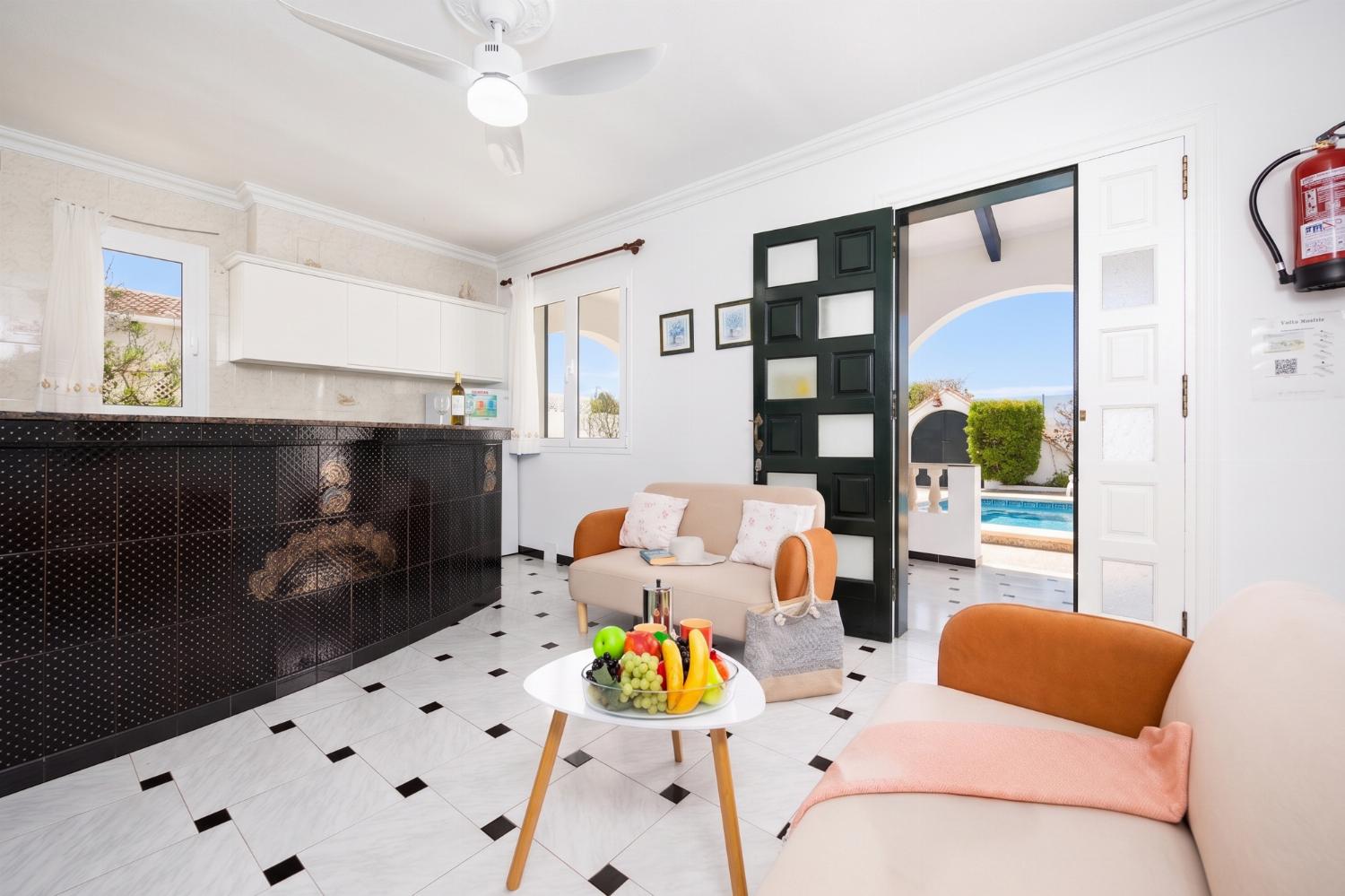 Open-plan living room with sofas, kitchen, WiFi internet, and satellite TV