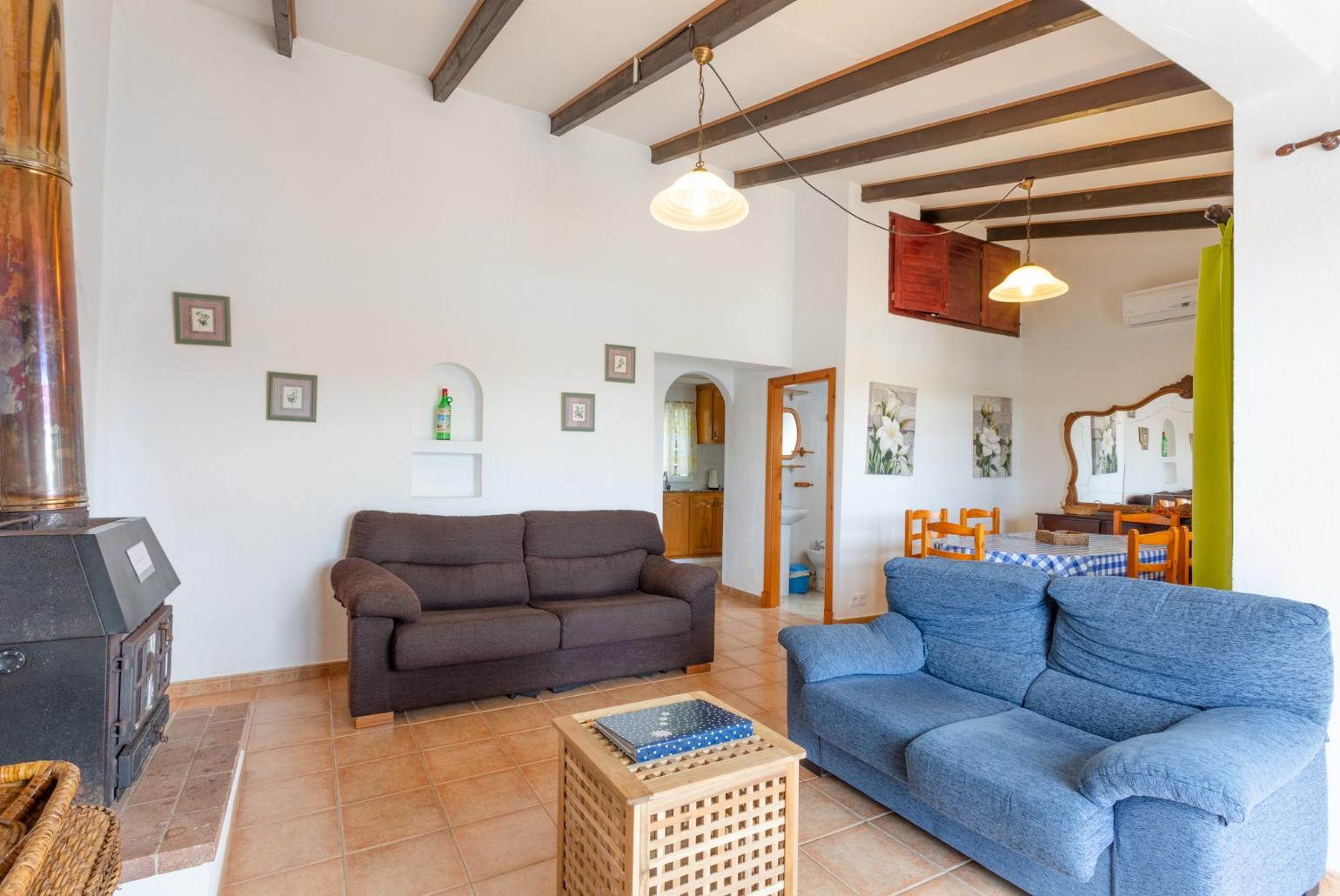 Living room with sofas, dining area, ornamental fireplace, A/C, WiFi internet, satellite TV, DVD player, and pool terrace access