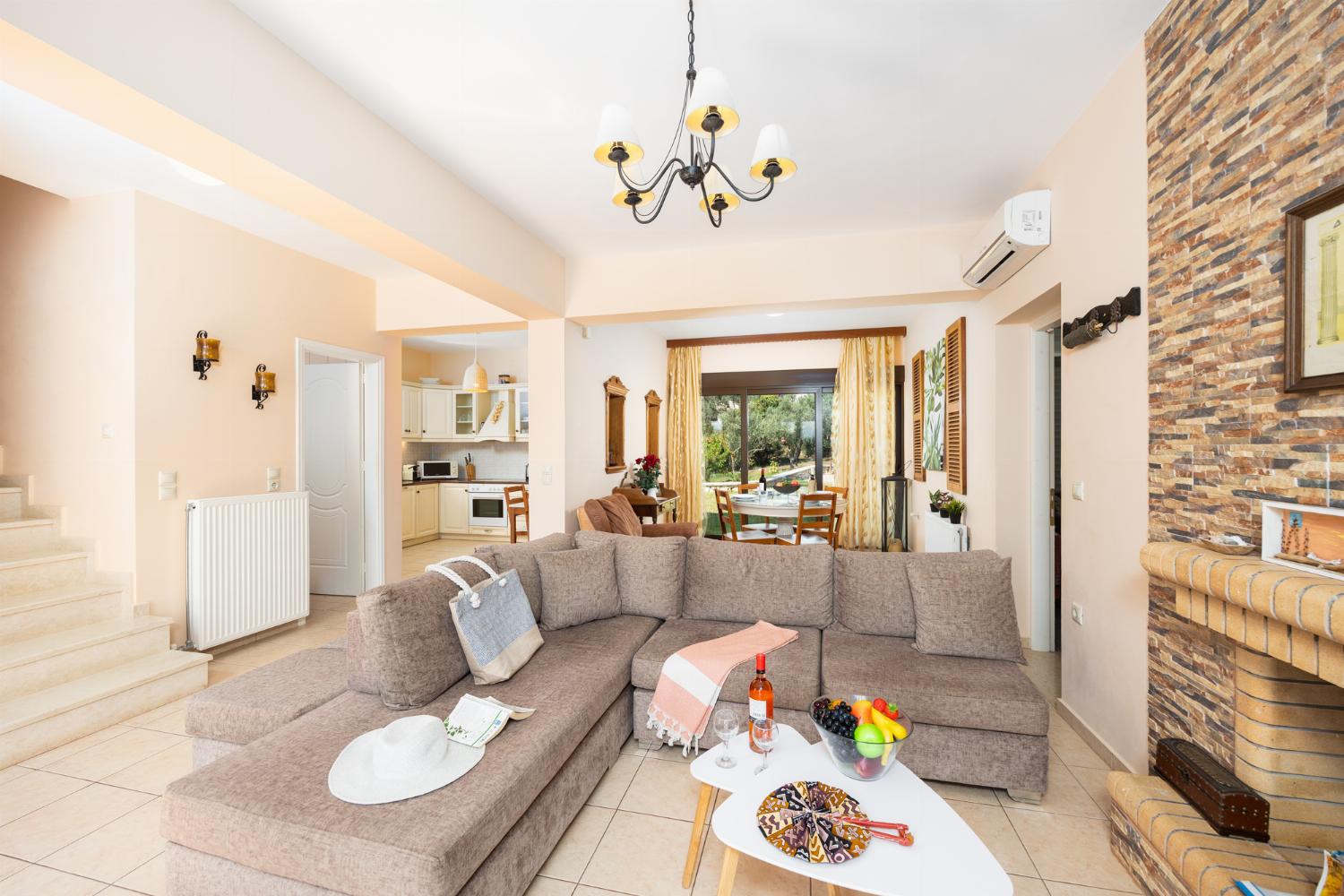 Open-plan living room with sofa, dining areas, kitchen, ornamental fireplace, A/C, WiFi internet, A/C, and satellite TV