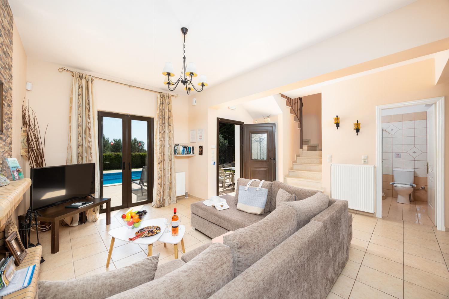 Open-plan living room with sofa, dining areas, kitchen, ornamental fireplace, A/C, WiFi internet, A/C, and satellite TV