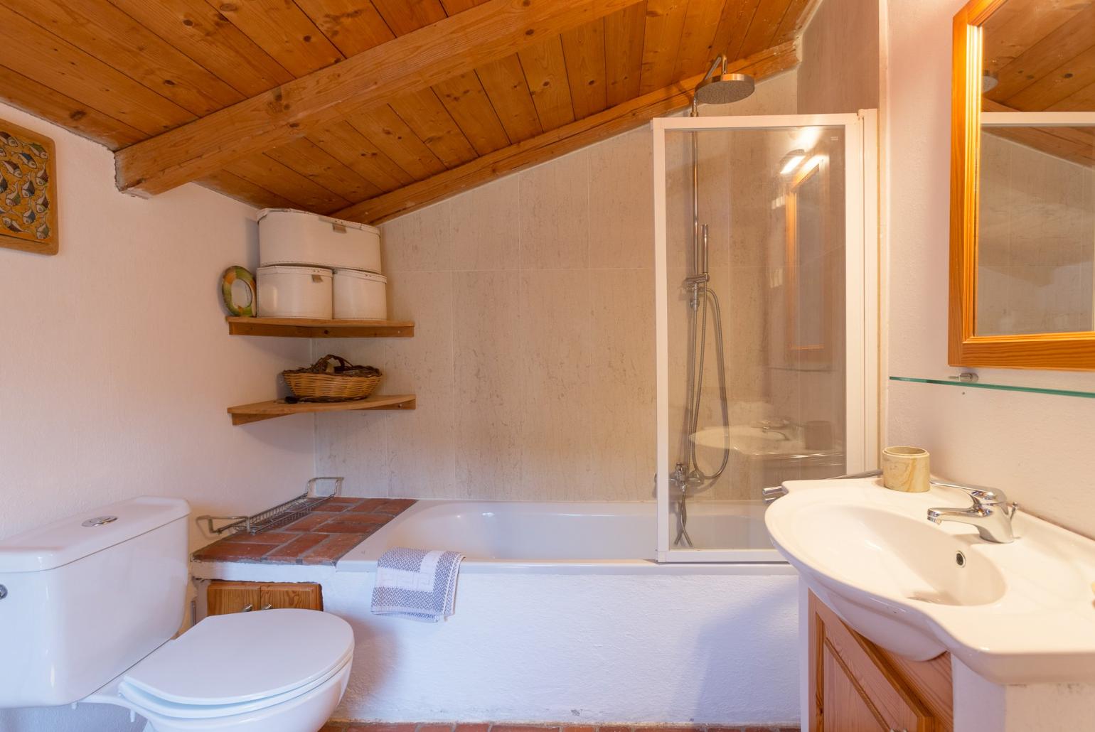 En suite bathroom with bath and overhead shower