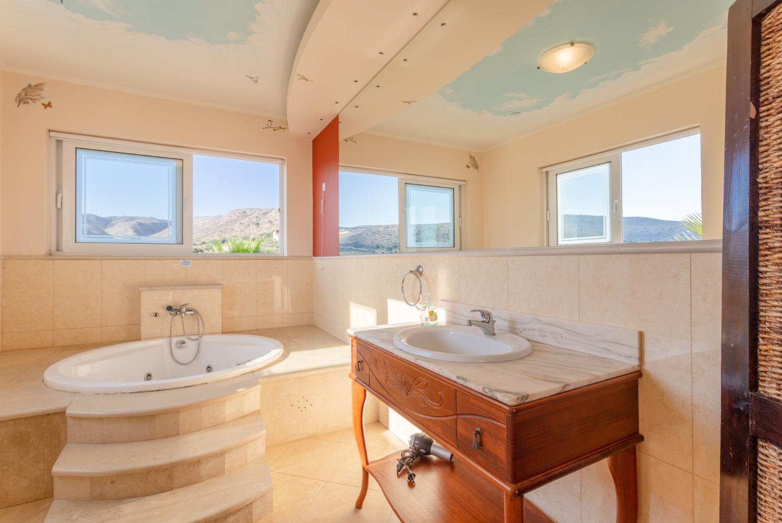 En suite bathroom with jacuzzi and shower